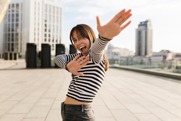 Tiro medio mujer sonriente divirtiéndose al aire libre