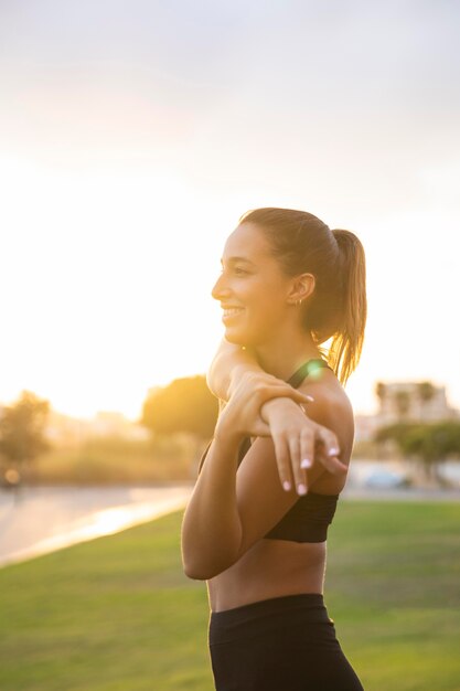 Tiro medio mujer sonriente estirando