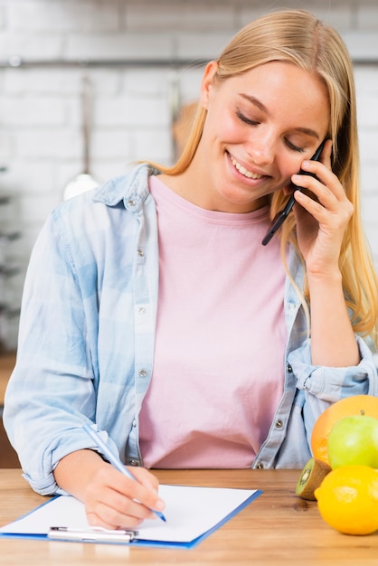 Foto gratuita tiro medio mujer sonriente hablando por teléfono