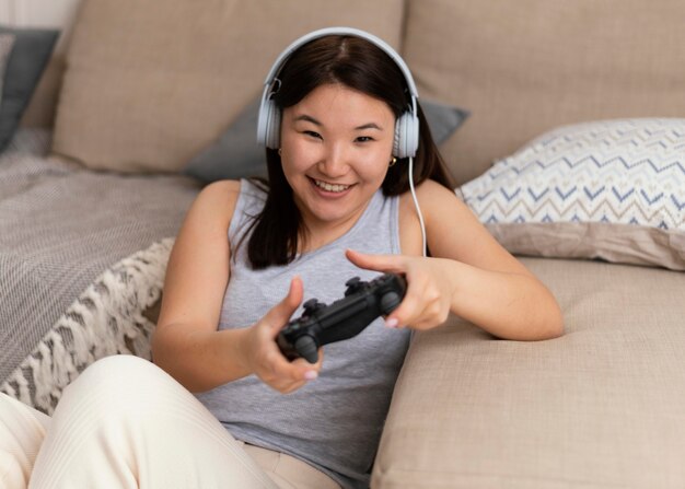 Tiro medio mujer sonriente jugando videojuegos