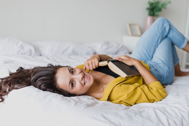 Tiro medio mujer sonriente con libro