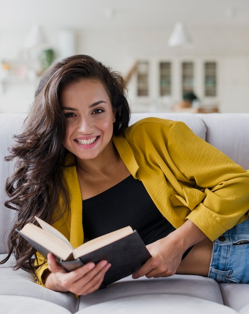 Tiro medio mujer sonriente con libro