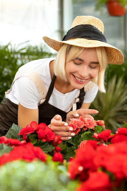 Tiro medio mujer sonriente mirando flores