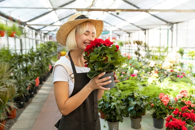 Tiro medio mujer sonriente oliendo flores