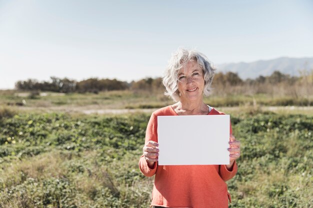 Tiro medio mujer sonriente con papel