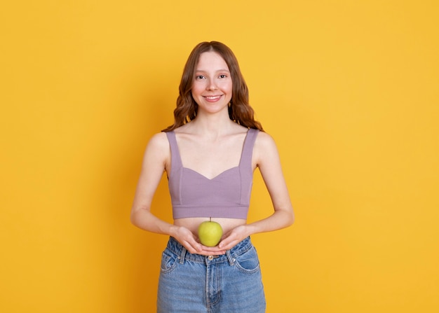 Tiro medio mujer sonriente sosteniendo apple