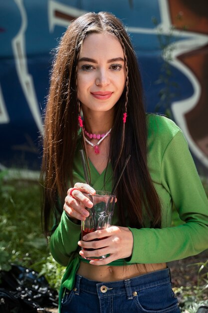 Tiro medio mujer sonriente sosteniendo bebida