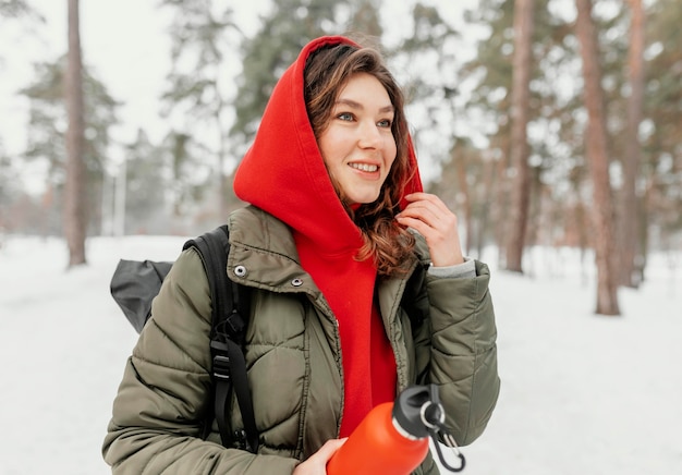 Foto gratuita tiro medio mujer sonriente sosteniendo una botella