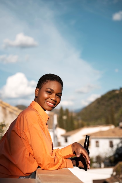 Foto gratuita tiro medio mujer sonriente sosteniendo una botella