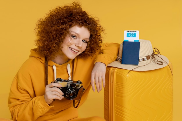 Foto gratuita tiro medio mujer sonriente sosteniendo la cámara