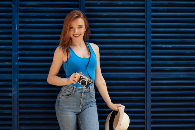 Tiro medio mujer sonriente sosteniendo la cámara