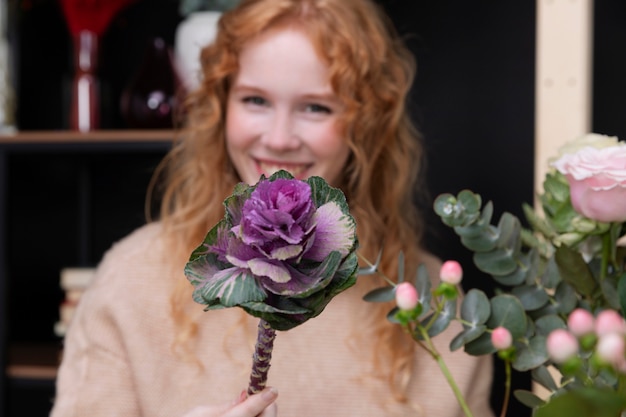 Foto gratuita tiro medio mujer sonriente sosteniendo flor