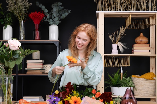 Tiro medio mujer sonriente sosteniendo flor