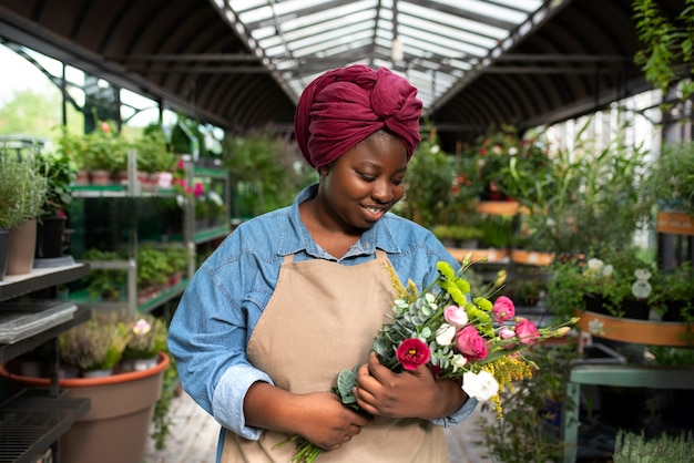 Tiro medio mujer sonriente sosteniendo flores