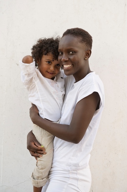 Foto gratuita tiro medio mujer sonriente sosteniendo kid