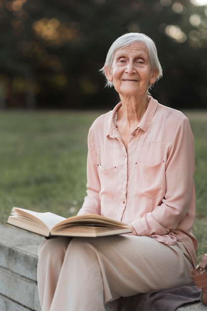 Foto gratuita tiro medio mujer sonriente sosteniendo libro