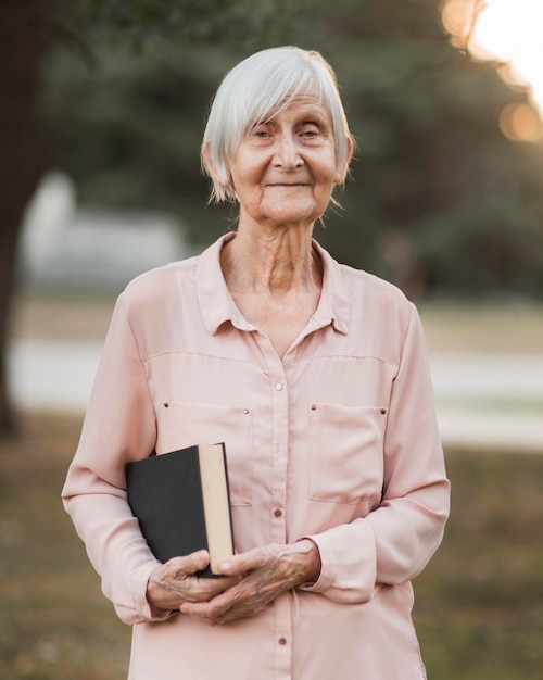 Tiro medio mujer sonriente sosteniendo libro