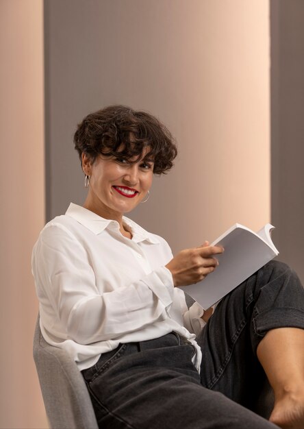 Tiro medio mujer sonriente sosteniendo libro