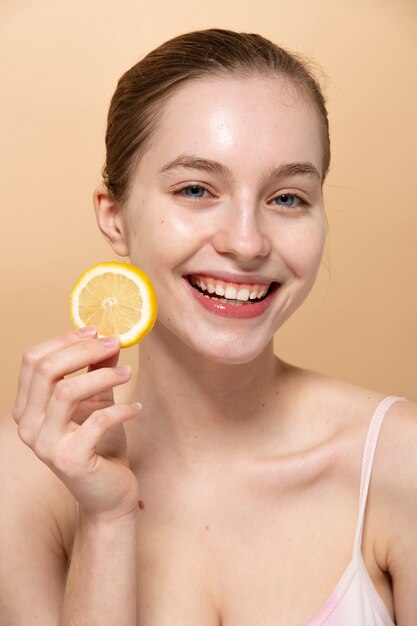 Tiro medio mujer sonriente sosteniendo limón