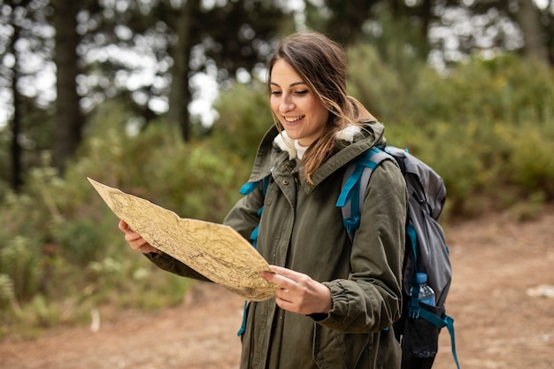 Tiro medio mujer sonriente sosteniendo mapa