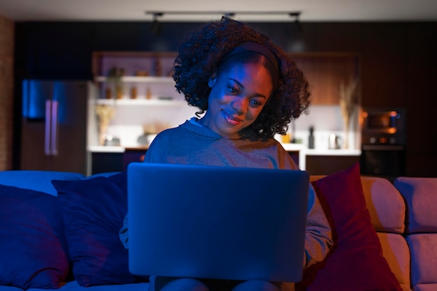 Foto gratuita tiro medio mujer sonriente sosteniendo portátil