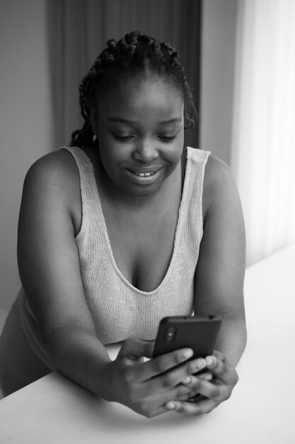 Tiro medio mujer sonriente sosteniendo smartphone