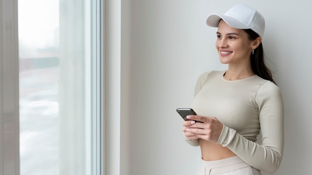 Tiro medio mujer sonriente sosteniendo smartphone