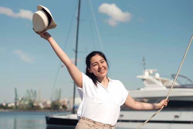 Tiro medio mujer sonriente sosteniendo sombrero