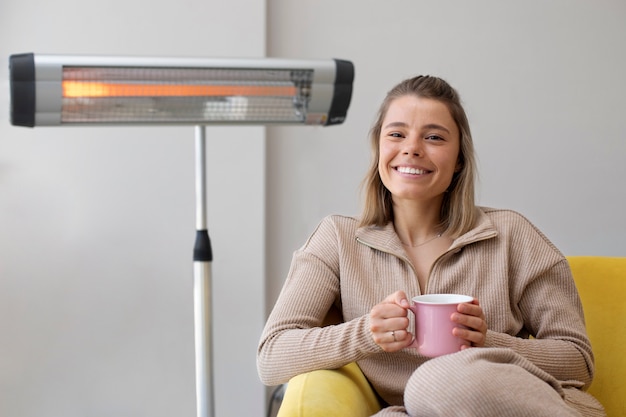 Foto gratuita tiro medio mujer sonriente sosteniendo la taza de café