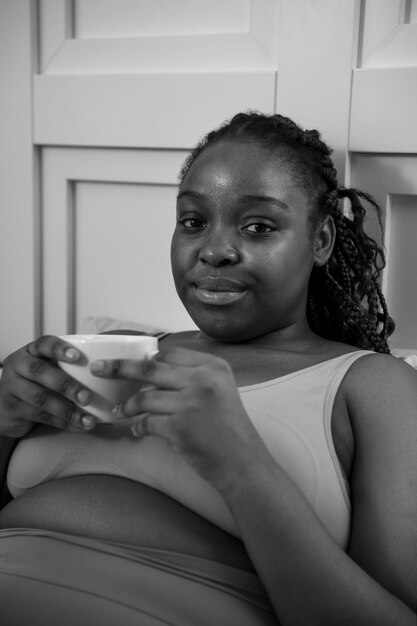 Tiro medio mujer sonriente sosteniendo la taza de café