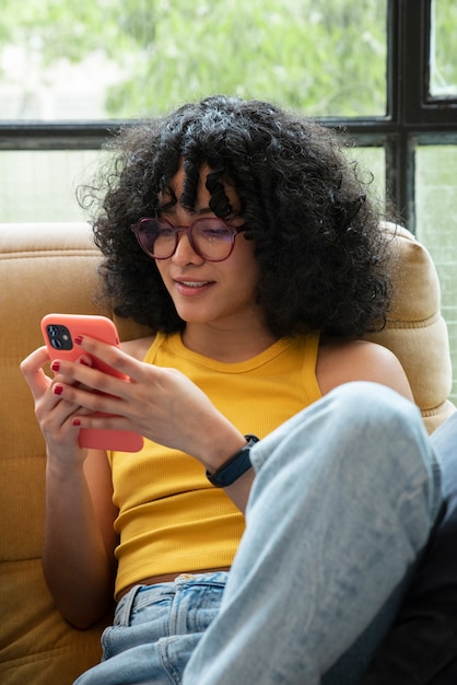 Tiro medio mujer sonriente sosteniendo teléfono