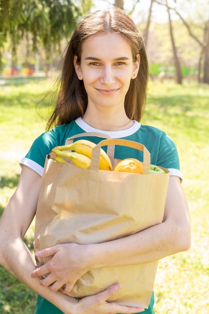 Tiro medio mujer sosteniendo una bolsa de papel