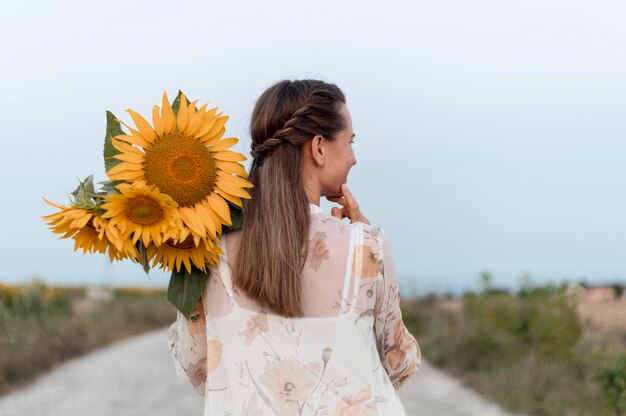 Tiro medio mujer sosteniendo flores