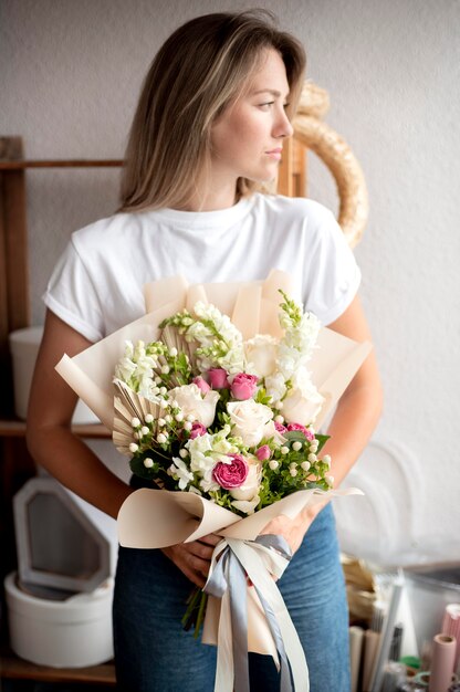 Tiro medio mujer sosteniendo flores