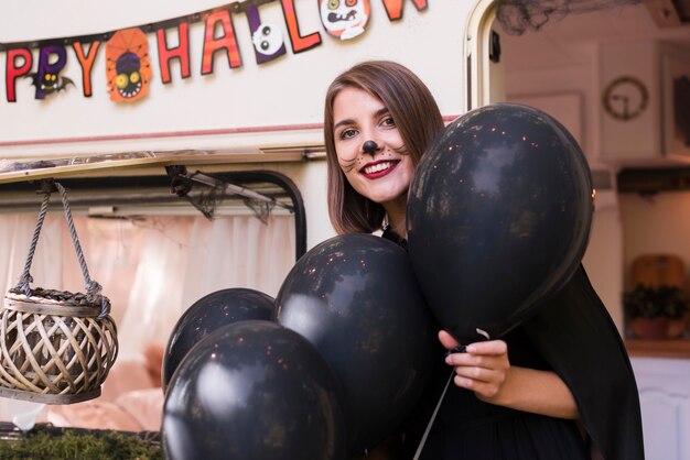 Tiro medio mujer sosteniendo globos negros