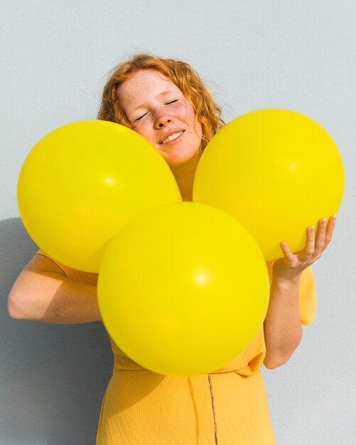 Tiro medio mujer sosteniendo globos