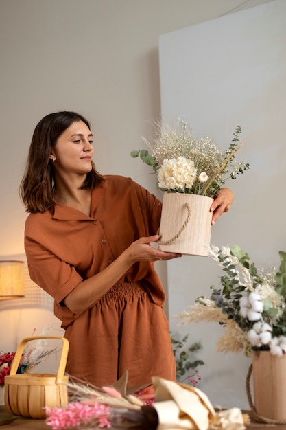 Tiro medio mujer sosteniendo hermosas flores