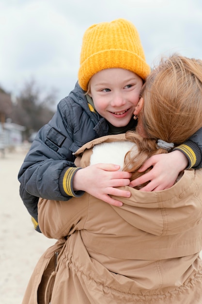 Tiro medio mujer sosteniendo niño sonriente