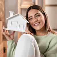 Foto gratuita tiro medio mujer sosteniendo pequeña casa