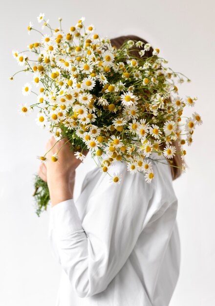 Tiro medio mujer sosteniendo ramo de flores