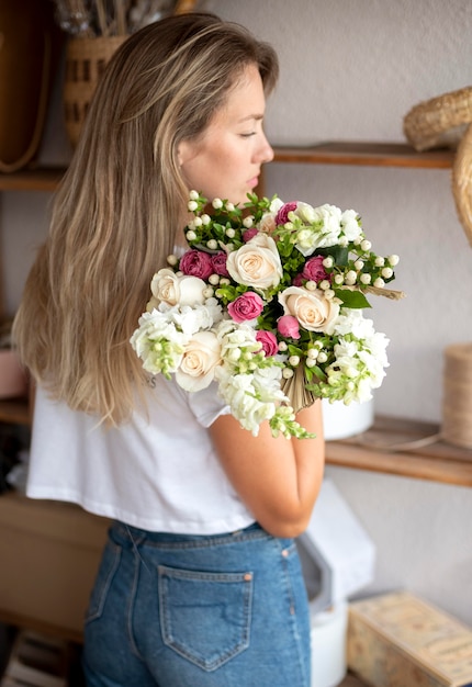 Tiro medio mujer sosteniendo ramo de flores