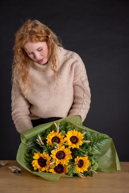 Tiro medio mujer sosteniendo ramo de flores