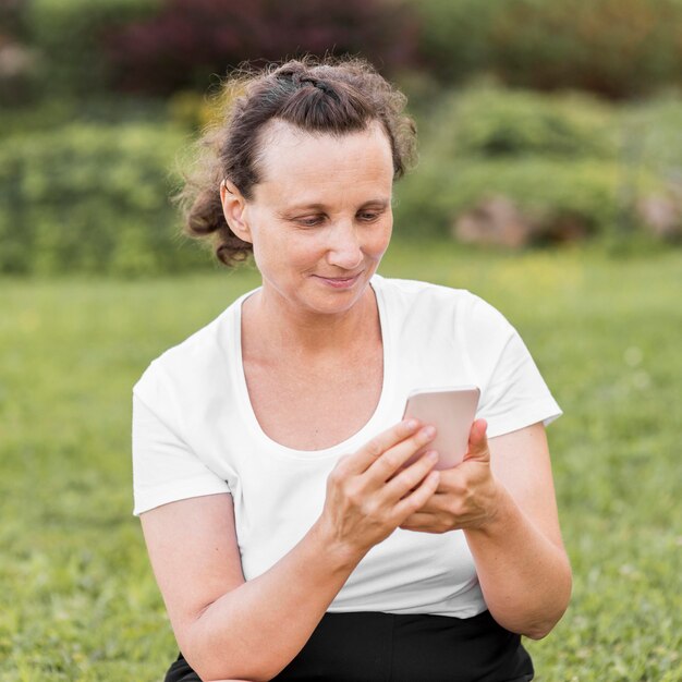 Tiro medio mujer sosteniendo smartphone