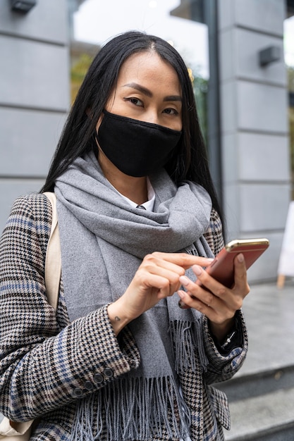 Tiro medio mujer sosteniendo smartphone