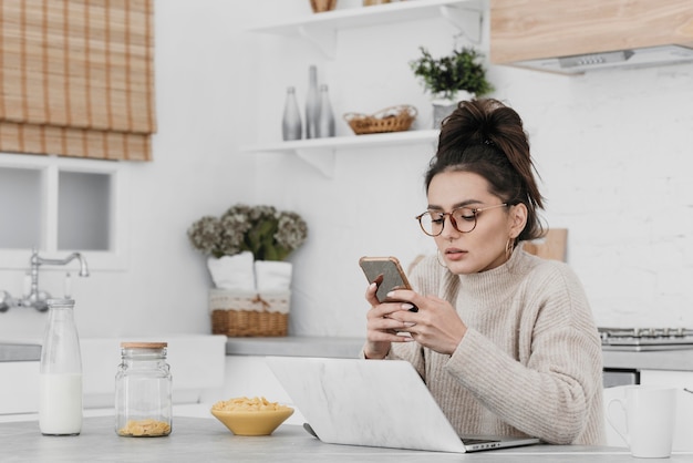 Tiro medio mujer sosteniendo smartphone