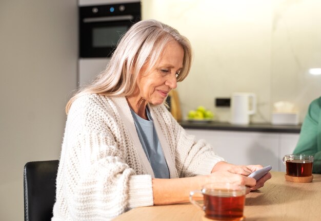 Tiro medio mujer sosteniendo smartphone