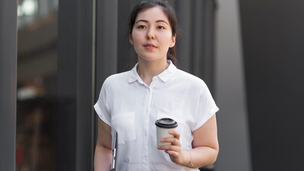 Tiro medio mujer sosteniendo la taza de café