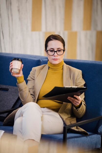 Tiro medio mujer sosteniendo la taza de café