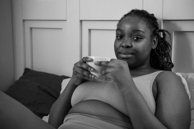 Tiro medio mujer sosteniendo la taza de café