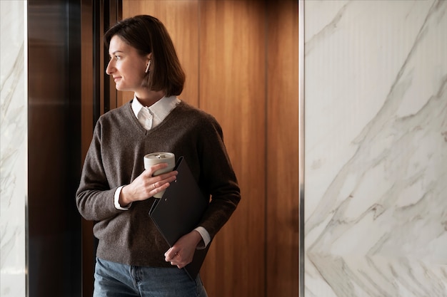 Tiro medio mujer sosteniendo la taza de café